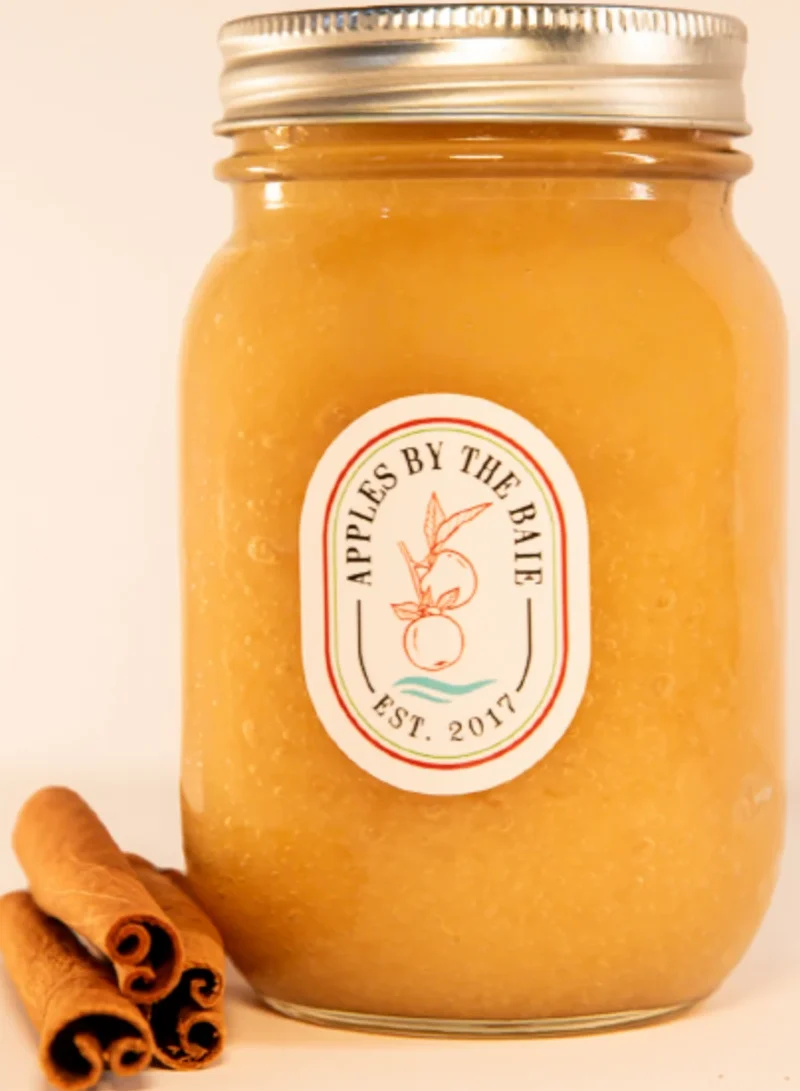 Jar of smooth apple sauce with cinnamon sticks